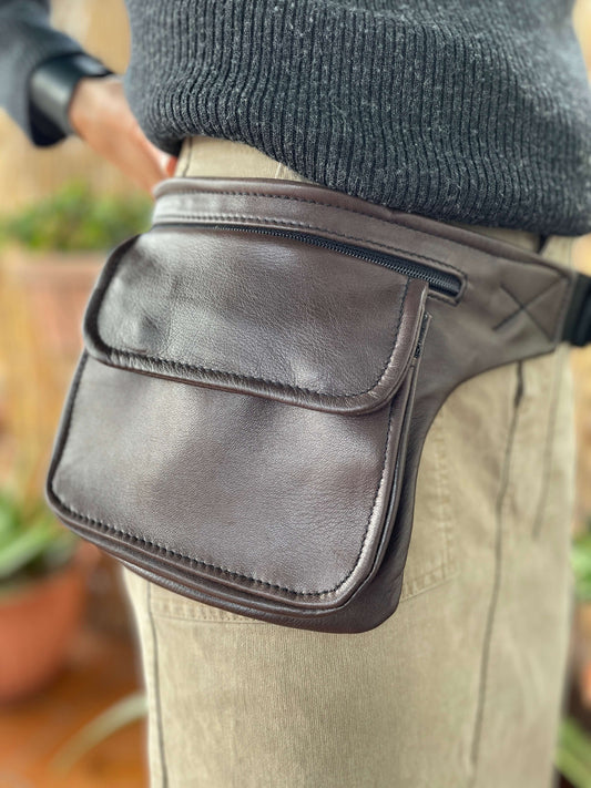 Riñonera artesanal hecha en cuero con forma cuadrada y en color marrón